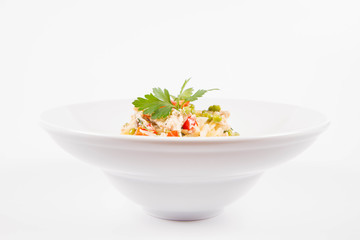 Spaghetti with cream sauce with smoked mackerel, peas ,bell pepper and some parsley on a white plate on a white background