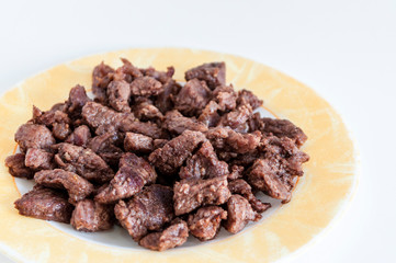 Perspective close-up shoot of tasty meat on small plate with white background