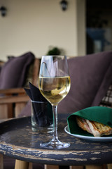 Glass with cold white wine on wooden table