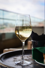 Glass with cold white wine on wooden table