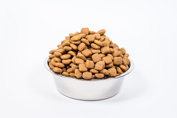 Full Cup with a slide of dry pet food isolated on white background. Metal bowl for cat or dog. The concept of proper nutrition, abundance of food, the harm of overeating, health hazards. Copy space