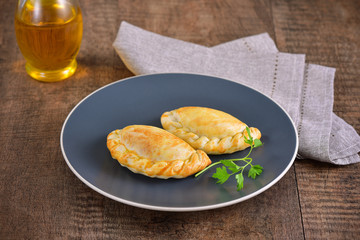 Meat roasted empanas on wooden background