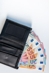 EURO-Geldscheine stecken in einem schwarzen Portemonnaie und stehen für Bargeld, Cash, Reichtum, passives Einkommen und Bezahlung im Finanzsektor