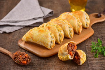 Meat roasted empanas on wooden background