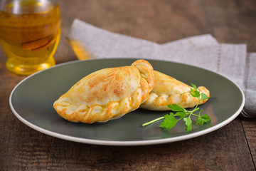 Meat roasted empanas on wooden background