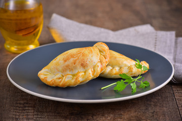 Meat roasted empanas on wooden background