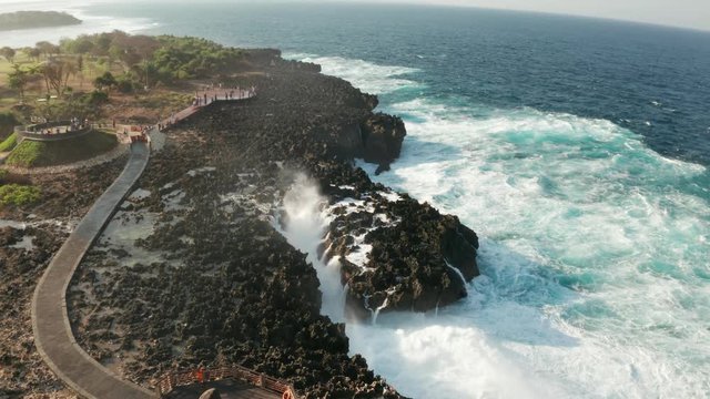 Aerial drone view of sea with waves crushing over Nusa Dua cliffs in Bali, Indonesia