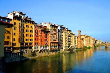 View from a Bridge Overlooking the River in the Middle of Florence Italy With Colored Houses with Balconies on the Water's Edge