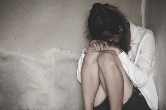 Depression or domestic violence Concept, Black and white image of a young woman crying and covering her face useful to illustrate stress.