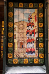 BARCELONA, SPAIN JUNE 22, 2019: A picture of a mosaic showing people taking part in acrobatic competitions in setting up a tower with people. An image of specially painted tiles and pieces of glaze on