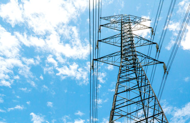 Electricity pylons with blue sky and white clouds. High voltage grid tower with wire cable at distribution station. High voltage electric tower and transmission lines.