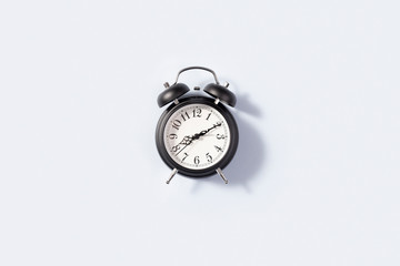 Black retro alarm clock isolated on white background, alarm flat lay