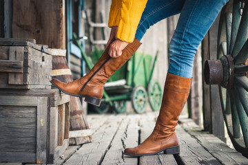 Woman fasten zipper on her leather boot