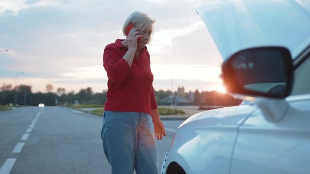 Close up attractive businesswoman speak on phone stand near opening the hood broken down car driver road service emergency travel woman auto breakdown call down nature slow motion