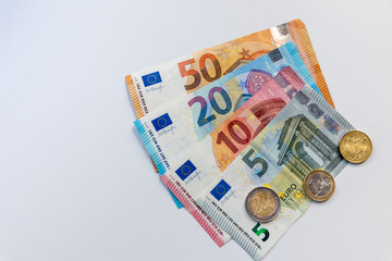 EURO-Bargeld aus EURO-Geldscheinen und EURO-Münzen liegt auf einem weißen Untergrund und steht...