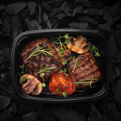 Fresh cooked meat on grill with rosemary and vegetables