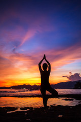 Caucasian woman practicing yoga at seashore