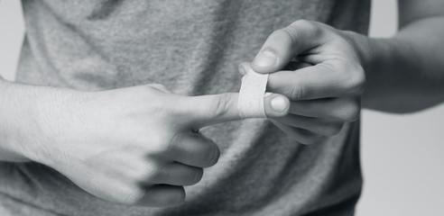 Man using adhesive tape on injured finger