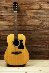 acoustic guitar near a beautiful wooden wall