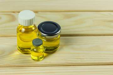 place for text, glass oil bottles, bottles with liquids of different shapes, light wooden background