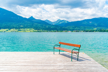A bench on wooden deck by Lake St. Wolfgang in the Salzkammergut resort region, Austria