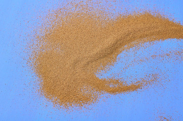 Scattered dry sea sand on blue scratched concrete