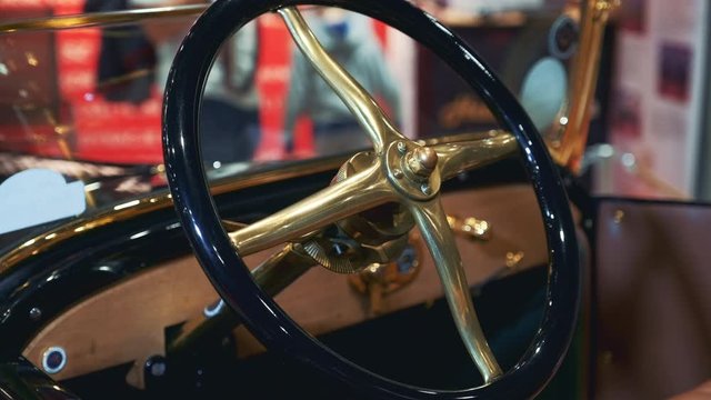 Black-golden steering wheel of retro car. Close-up view