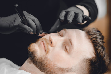 Barbershop. Hairdressers barber hair and beard with razor in salon