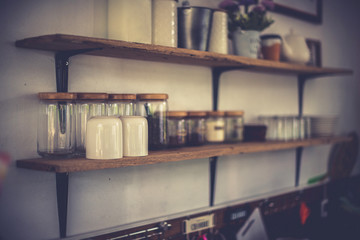 Coffee glass shelves and glass bottles in coffee cafe.