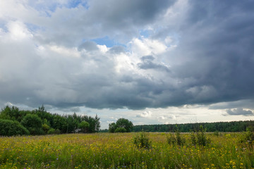 Landscape with thunderclouds over a green field. Russia Moscow region