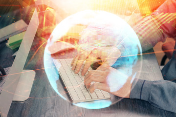 Double exposure of businessman working on laptop on background. International business hologram in front. Concept of success.