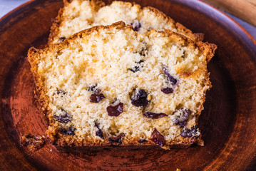 Pieces of homemade cake with raisins on a clay plate close-up.