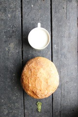 Bread with milk lies on the old vintage table.