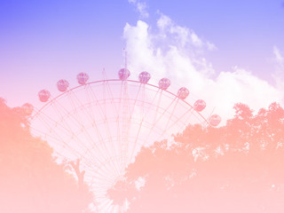 neon tinted. Ferris wheel on the background of blue sky