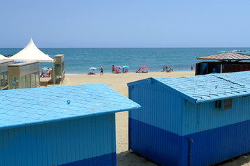 Cabines de plages bleues sur le sable.