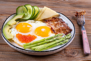 Close up view of the ketogenic diet breakfast on the white plate with a fork on rustic background