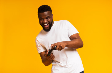 Excited black guy holding joystick and playing video games