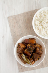 Homemade Filipino Adobo Pork with rice on a white wooden background, top view. Flat lay, overhead, from above. Copy space.