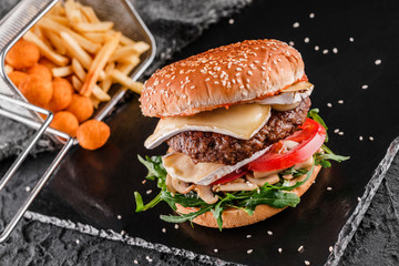 Tasty burger with cheese brie, blue cheese, mozzarella, tomatoes, arugula and fried stick balls,...