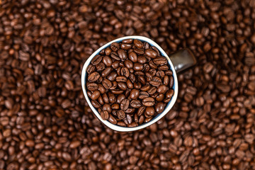 coffee beans background with a coffee mug full of coffee beans.