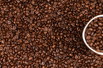 coffee beans background with a coffee mug full of coffee beans.