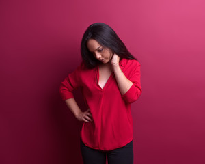 Thoughtful young girl in front of a red background