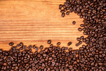 A coffee beans over wooden table top background.