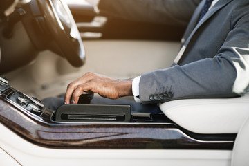African-american businessman shifting the gear stick, side view
