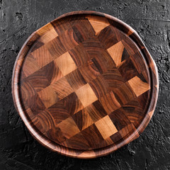 Chopping cutting board on dark stone background. Wooden texture. Top view