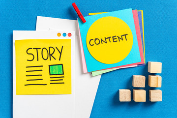 Social media content sharing and digital marketing concept made with paper cards with the words illustrated "story" and "content" and wooden block toys on blue texture background.
