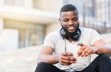Happy african american guy blog in social networks