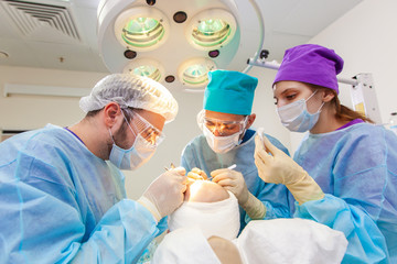 Baldness treatment. Hair transplant. Surgeons in the operating room carry out hair transplant...