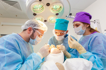 Baldness treatment. Hair transplant. Surgeons in the operating room carry out hair transplant surgery. Surgical technique that moves hair follicles from a part of the head.
