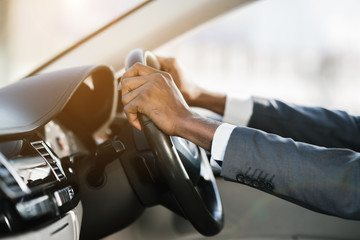 Afro businessman hands holding steering wheel, free space